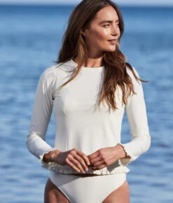 The Waterside Ruffle Rash Guard - White Sand 9 The Waterside Ruffle Rash Guard - White Sand -Classic Lady Wear Store WatersideRuffleRashGuardWhiteSandLifestyle2